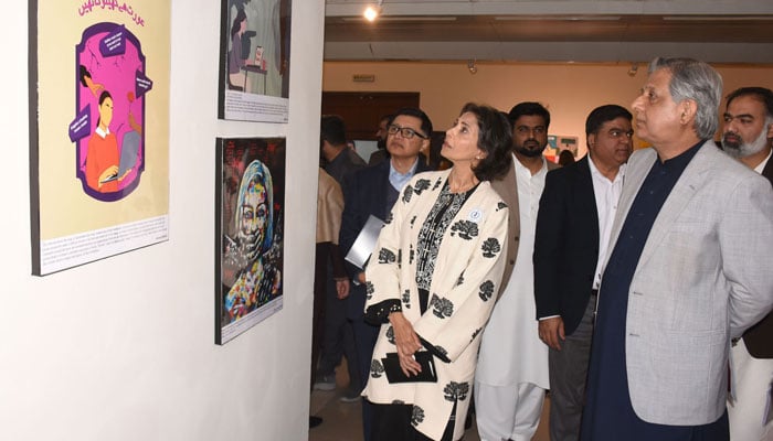 Federal Minister for Law and Justice Azam Nazeer Tarar looks at photos during the Art Exhibition at National Council of Arts in the Federal Capital on December 1, 2025. — Online