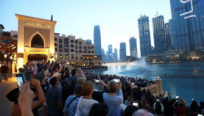 Tourists gather to watch a musical fountain in front of the Burj Khalifa, the tallest building in the world, in Dubai, United Arab Emirates, March 12, 2020. — Reuters