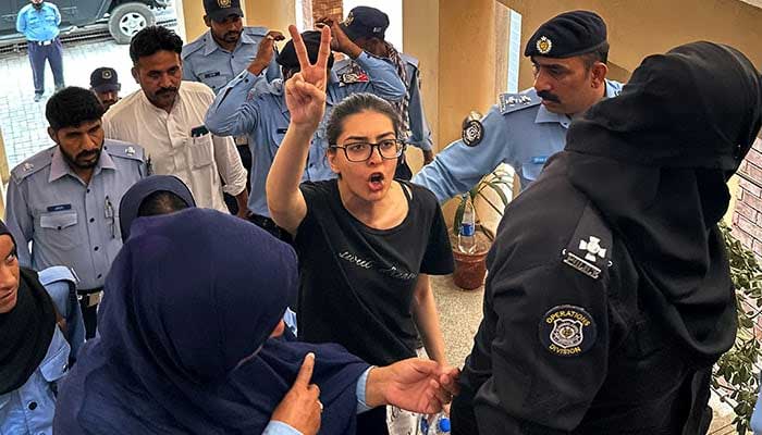 Police officials presents arrested lawyer and human rights activist Iman Mazari-Hazir (centre) before a court in Islamabad on August 20, 2023. — AFP