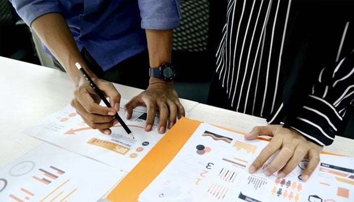Representational image of team members reviewing data charts during a strategy discussion.—Unsplash/File