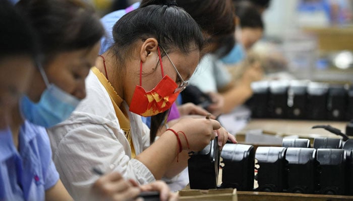 Employees work on an assembly line producing speakers at a factory in Fuyang city, in Chinas eastern Anhui province. —AFP/File