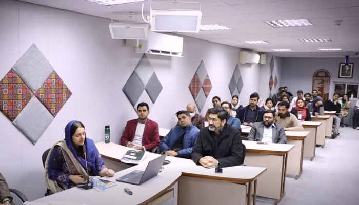Dr Aqsa Shabbir, from Lahore College for Women University (left), addresses a seminar on “Clean air, green future: smog mitigation, resilience and carbon credit feasibility” hosted by PIDE at Quaid-i-Azam University Campus on December 4, 2025. — Screengrab via Facebook@PIDEIslamabad