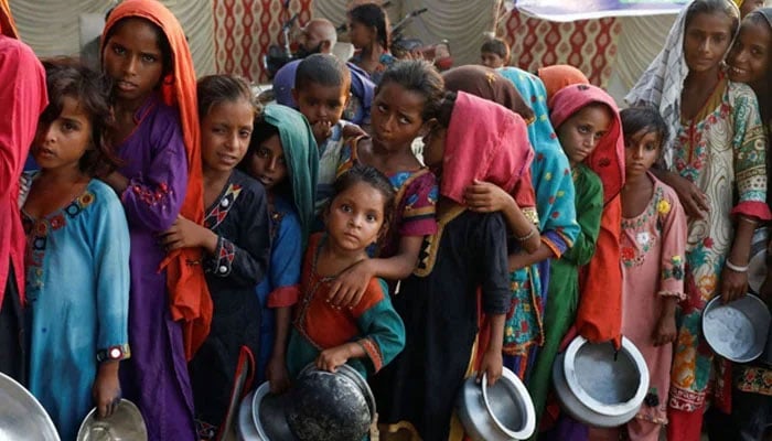 This representational image shows flood victims gathering to receive food handouts in a camp following rains and floods during the monsoon season in Sehwan on September 14, 2022. — Reuters