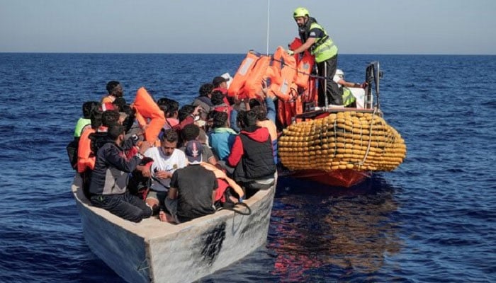 Crew members of NGO rescue ship Ocean Viking give lifejackets to migrants on an overcrowded boat in the Mediterranean Sea, October 25, 2022. —Reuters
