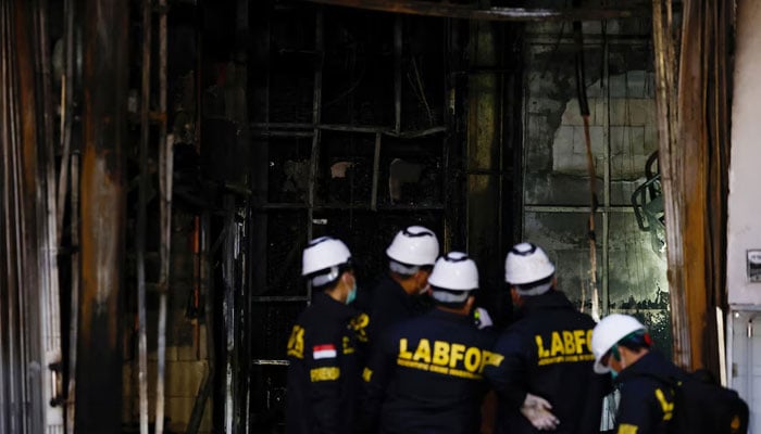 Forensic police officers inspect the Terra Drone Agri building damaged by fire, in Jakarta, Indonesia, December 9, 2025.—Reuters