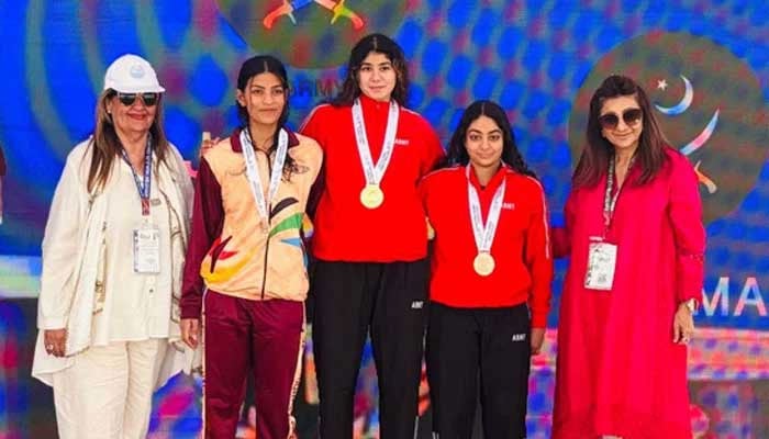 Pakistan Armys Jehanara Nabi (centre) poses for a picture after winning National Games gold medal in 400m individual medley in Karachi on December 9, 2025. — Reporter/Faizan Lakhani