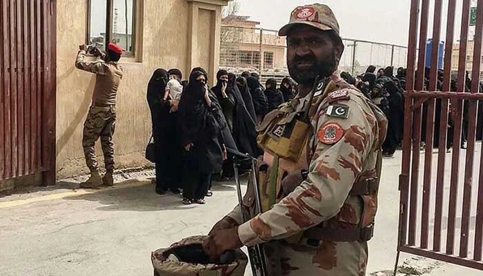 Security personnel stand guard as pilgrims evacuated from Iran cross the Pakistan-Iran border in Taftan. — AFP/File