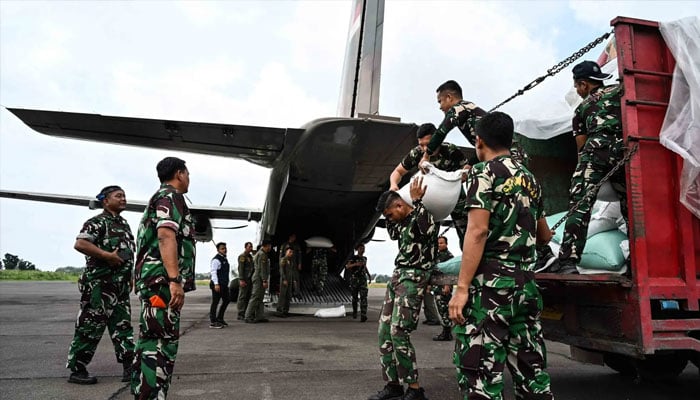 Indonesian military personnel move sacks of rice to load them onto an aircraft as part of relief supplies to be delivered to flood-affected areas in North Sumatra and Aceh, at Soewondo Air Base in Medan, North Sumatra, on December 12, 2025. — AFP