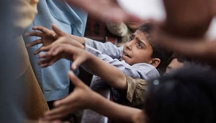 Children attempt to grab hold of ration bags during a charity drive. — Reuters/File