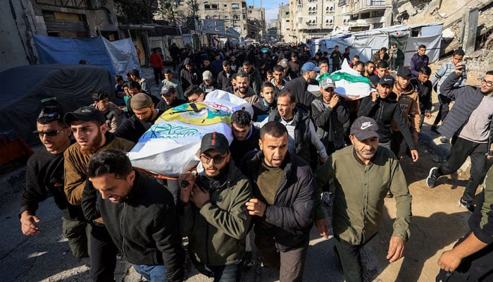 Mourners carry bodies during the funeral of Hamass senior commander Raed Saed and his aides, who were killed in an Israeli strike a day earlier, in Gaza City, December 14, 2025. —Reuters