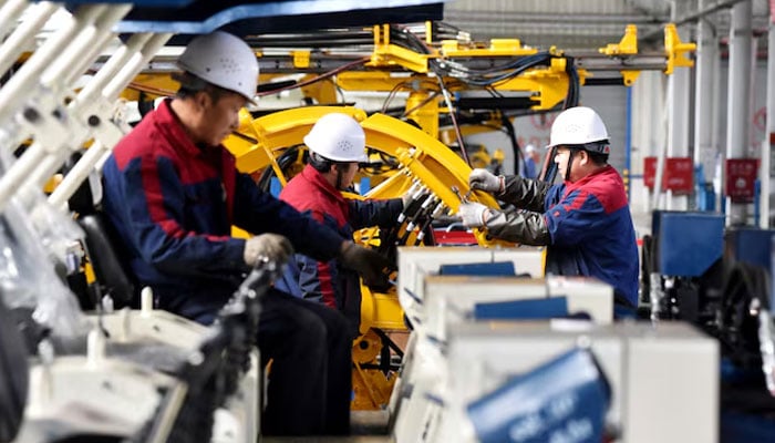 Employees work on a drilling machine production line at a factory in Zhangjiakou, Hebei province, China, November 14, 2018. — Reuters