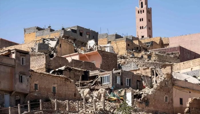The minaret of a mosque stands behind damaged or destroyed houses in Moulay Brahim, Al-Haouz province, on September 9, 2023. —AFP