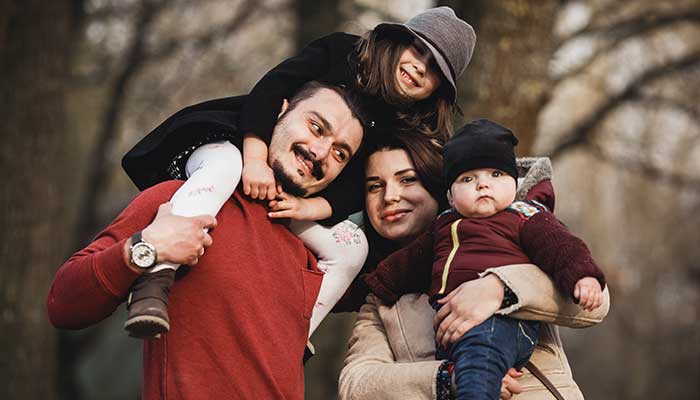 Representational image shows parents with kids posing in park. — Freepik