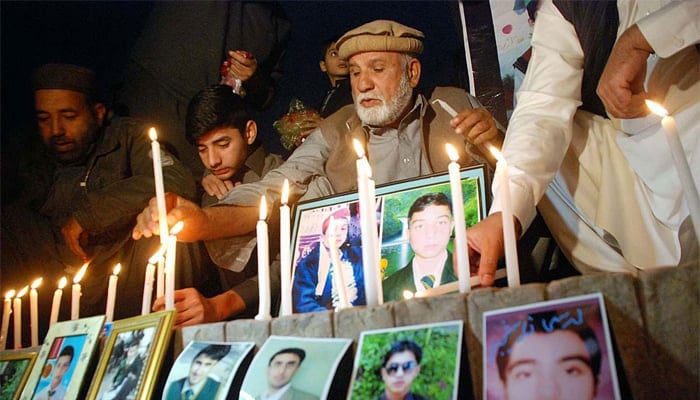 Relatives of APS victims hold candlelight vigil at Yadgar-e-Shuhda to pay tribute to martyrs of the APS terrorist attack in December 2016. — APP/File