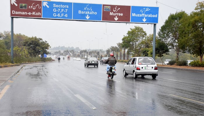 Motorists on their way at Srinagar Highway during rainy weather, in the Federal Capital on December 21, 2025. — Online