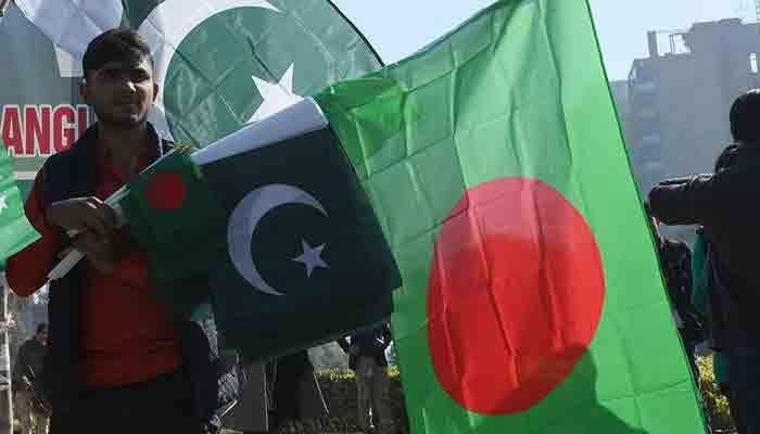 A man holding flags of Pakistan and Bangladesh. — APP/File