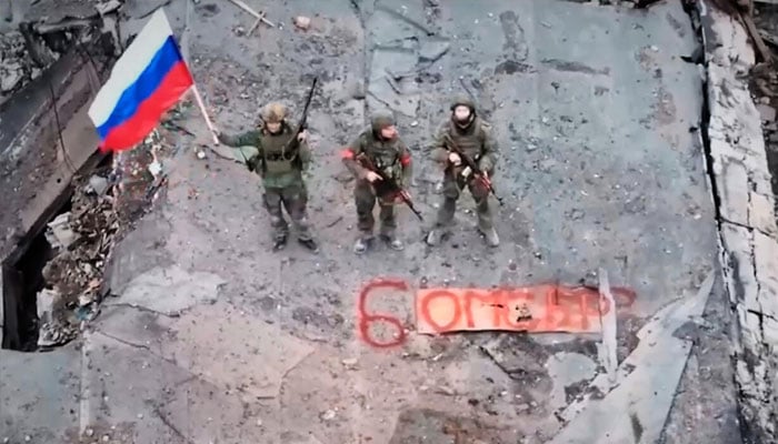 Russian soldiers hold a flag in Siversk, a city in the Donetsk region, Ukraine, on December 11, 2025. — Russian Defense Ministry Press Service