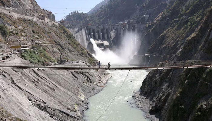 Labourers walk on a bridge near the 450-megawatt hydropower project located at Baglihar Dam on the Chenab river which flows from Indian Kashmir into Pakistan, at Chanderkote, about 145 km (90 miles) north of Jammu October 10, 2008. — Reuters