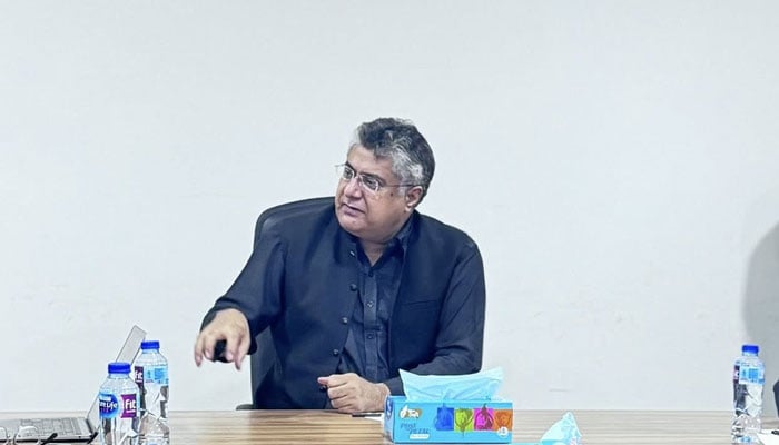 Sindh Population Welfare Secretary Hafeezullah Abbasi looks on as he speaks during a meeting with someone. — Facebook@Populationwelfaredeptgossindh/File