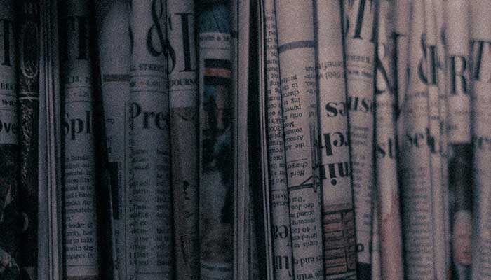 Representational image shows a row of newspapers sitting on top of a shelf. — Unsplash