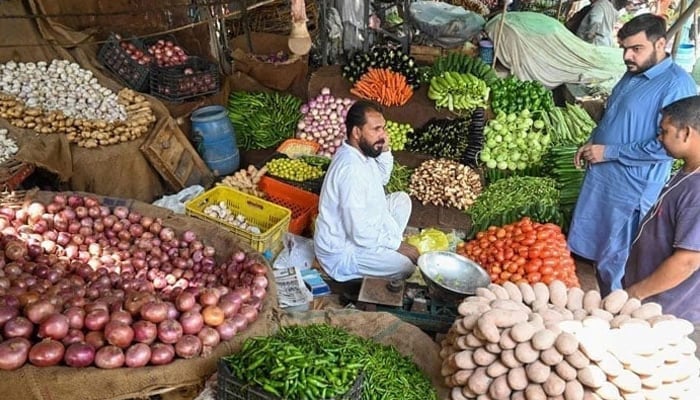 This image shows the consumers buying fresh vegetables from a local market. — AFP/File