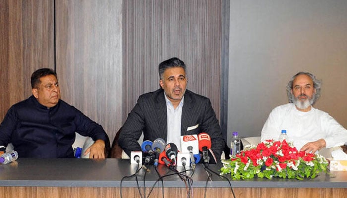Chairman APTMA Kamran Arshad (center) addresses a press conference.—APP/File