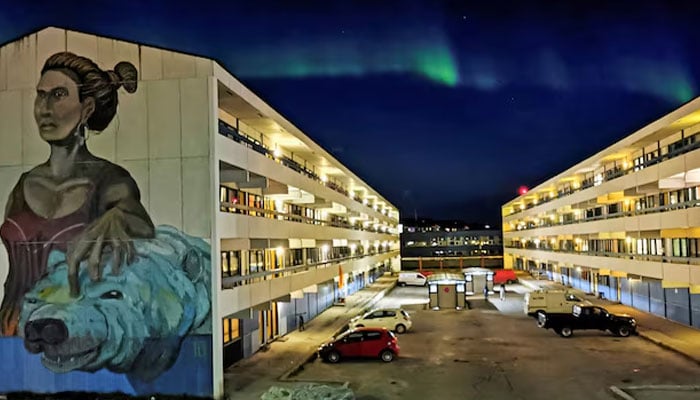 The Aurora Borealis (Northern Lights) is seen behind a building with social housings with a mural in Nuuk, Greenland, September 17, 2021.—Reuters