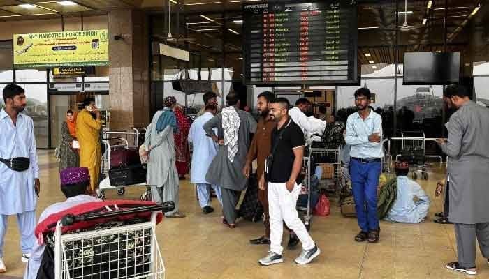 Passengers wait outside at Jinnah International Airport in Karachi, Pakistan, May 7, 2025. — AFP