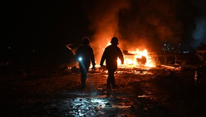 Firefighters inspecting the strike site. —AFP/File