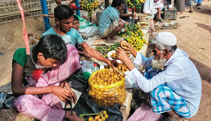 Rohingya refugees sell vegetables at a roadside stalls in the Kutupalong refugee camp in Ukhia on Sunday. —AFP/File