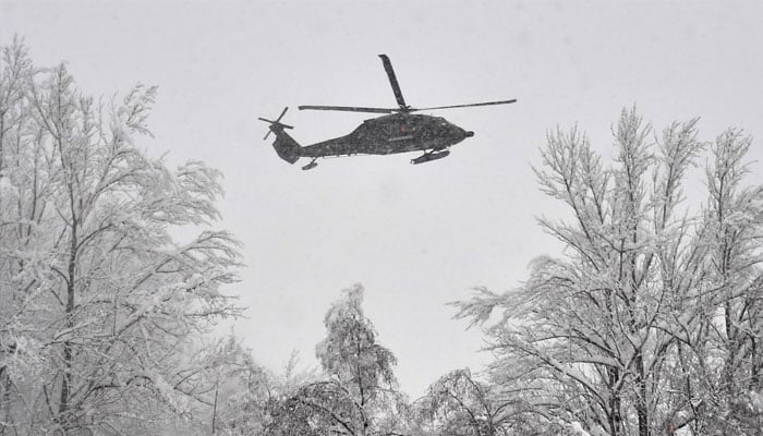 A military helicopter flies over the Austrian-German border after heavy snowfall.—AFP/File