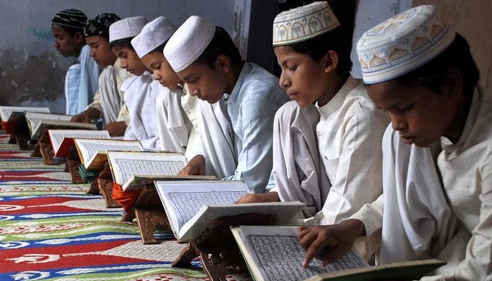Children read the Quran at a madrasa on August 23, 2009. — Reuters