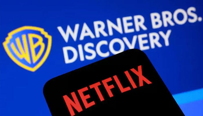 Warner Bros Discovery logo in background and Netflix logo on mobile screen can be seen. —Reuters/File