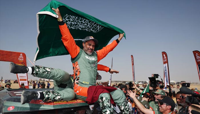 Dacias Nasser Al-Attiyah and Fabian Lurquin celebrate after winning in the car category. —Reuters