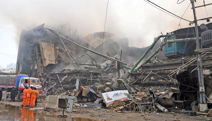 Rescue workers stand outside a collapsed shopping centre due to fire in Karachi on January 18, 2026. — Online