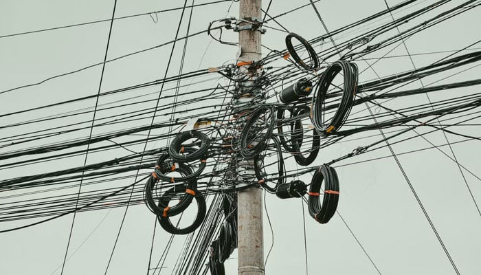 Electric wires can be seen connecting a pole. — Unsplash/File