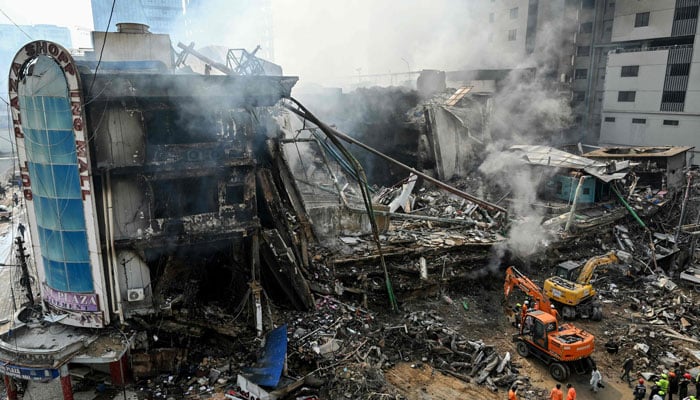 Rescue workers search amid the debris using excavators after a massive fire at a shopping mall in Karachi on January 19, 2026. — AFP