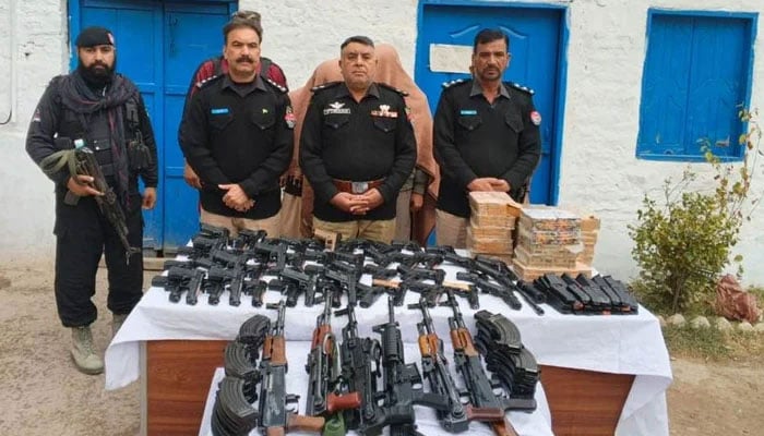 This representational image shows KP police personnel pictured with recovered weapons and ammunition on December 30, 2025. — Facebook@dpokohat
