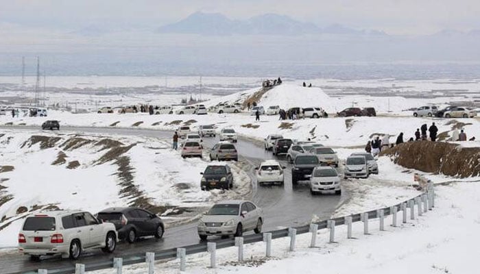 Above, commuters drive through a snow-covered road near the Pakistan–Afghanistan border in Chaman on Jan. 22, 2026. —AFP