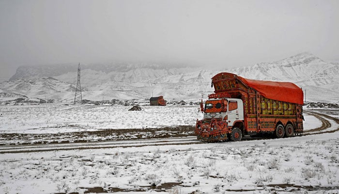 A truck drives through a snow-covered road on the outskirts of Quetta on January 22, 2026. — AFP