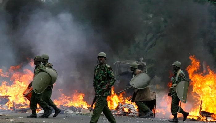 Riot police move to dismantle a burning roadblock in Nairobi on December 31, 2007 amid protests against a disputed election that handed President Mwai Kibaki a second term in office. —Reuters