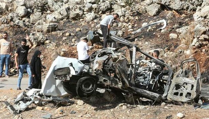 People inspect the wreckage of a vehicle targeted by an Israeli strike in the southern Lebanese village of Haruf on October 25, 2025. —AFP