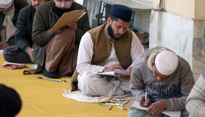 Students of Islamic seminary solve papers during the Annual Examination in Peshawar on February 1, 2025. — PPI