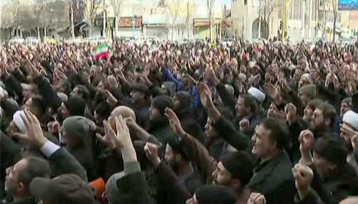 This grab taken from handout video footage released by Iran Press on January 9, 2026, shows pro-government demonstrators chanting slogans as they march along a main street in Khorramabad, western Iran. — AFP