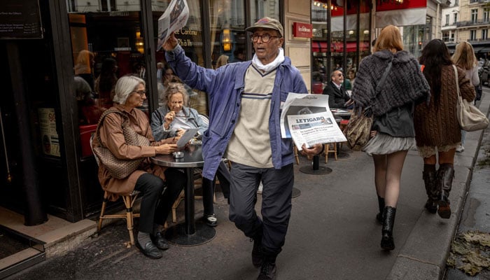 Pakistani born 73-year-old newspaper hawker Ali Akbar sells newspaper copies in the street of the Latin Quarter in Paris on September 16, 2025.— AFP