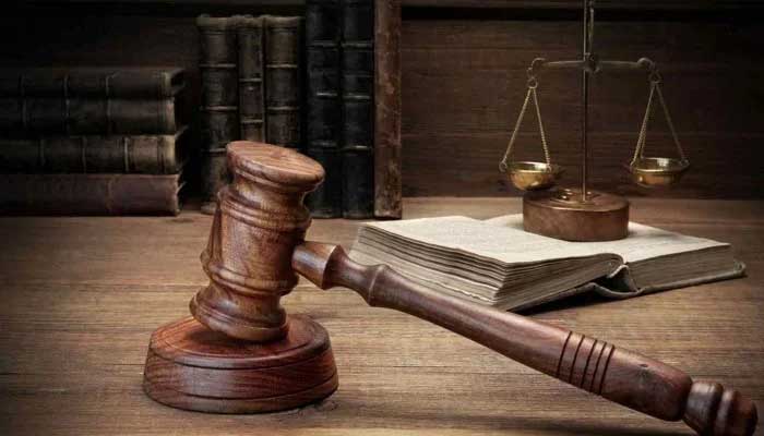 Representational image of a gavel and a sound block with a set of balance scales (scales of justice) seen in the background. — Unsplash/File