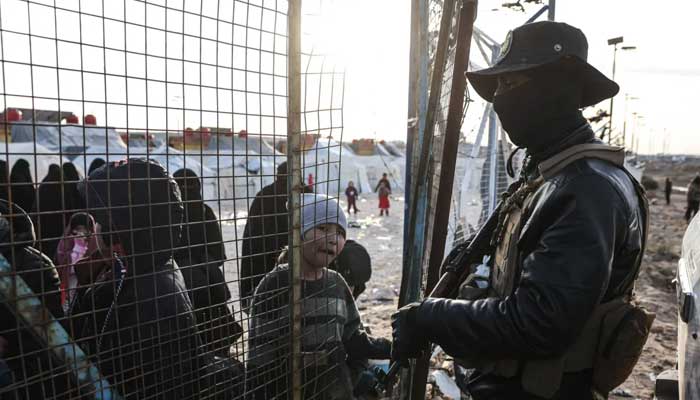 Syrian internal security forces stand guard along the fence of Al-Hol camp in the desert region of Syrias Hasakeh province on January 21, 2026. — AFP
