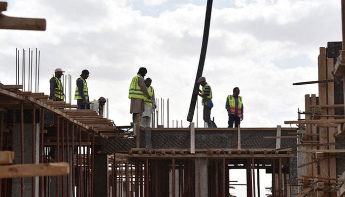 The representational image shows construction workers busy at a site. — AFP/File