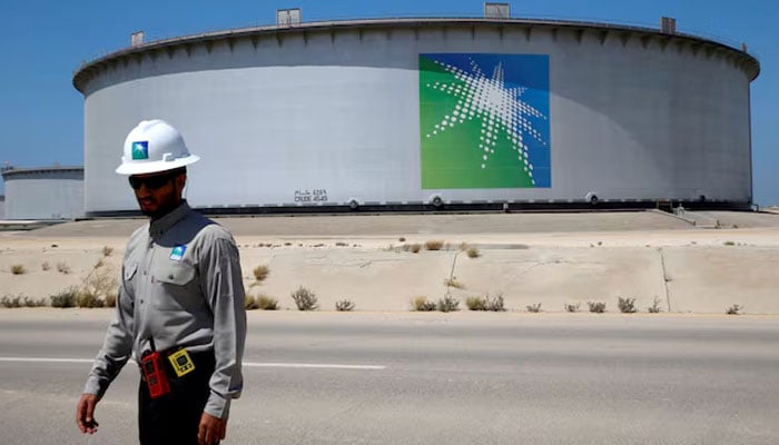 An Aramco employee walks near an oil tank at Saudi Aramcos Ras Tanura oil refinery and oil terminal in Saudi Arabia, May 21, 2018.—Reuters