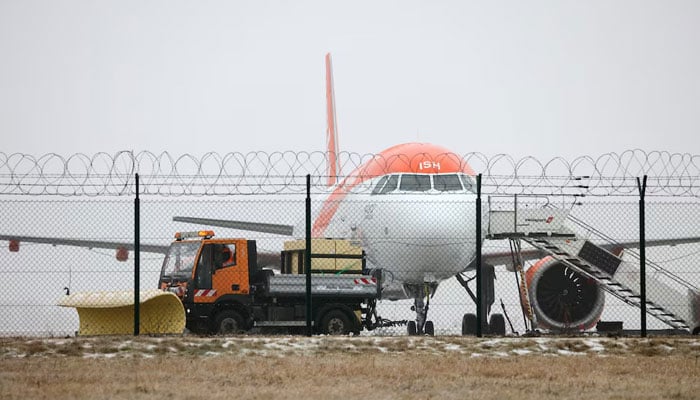 An easyJet plane, as a de-icing vehicle works at Berlin Brandenburg Airport, which was closed due to severe ice on taxiways caused by freezing rain, in Berlin, Germany, February 6, 2026. — Reuters
